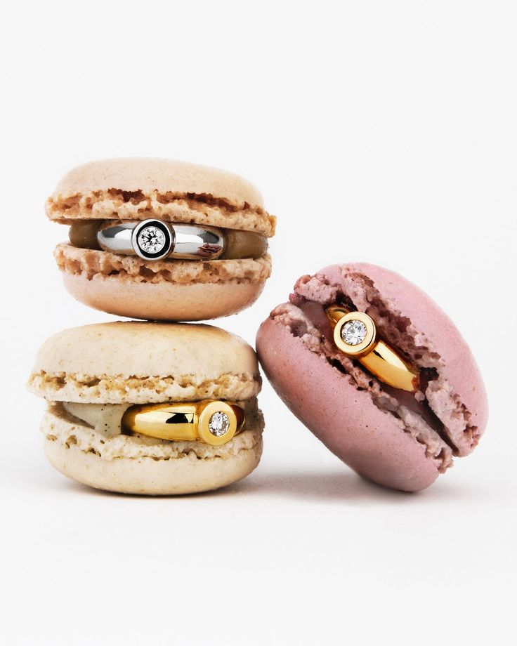 Bagues en or et diamants glissées dans des macarons