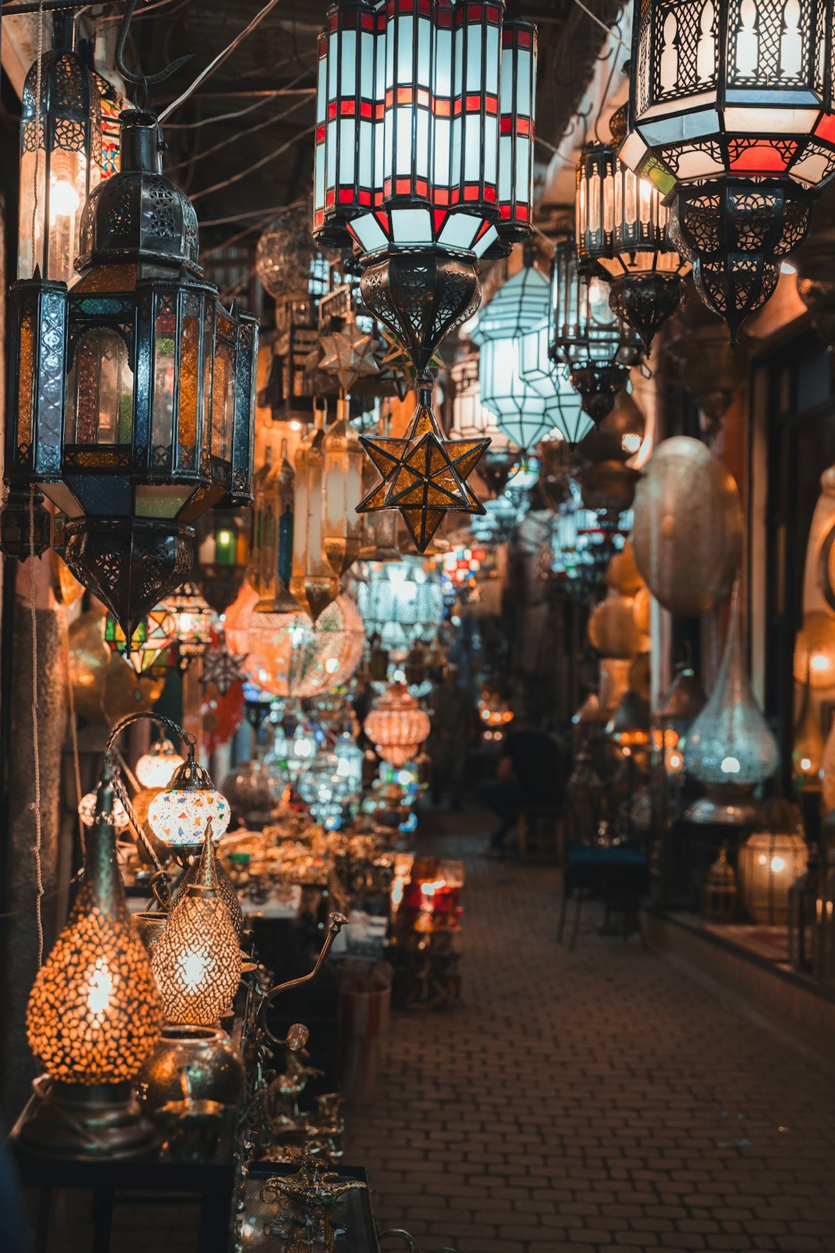 Lanternes marocaines dans un souk de Marrakech, savoir-faire local d'une DMC au Maroc