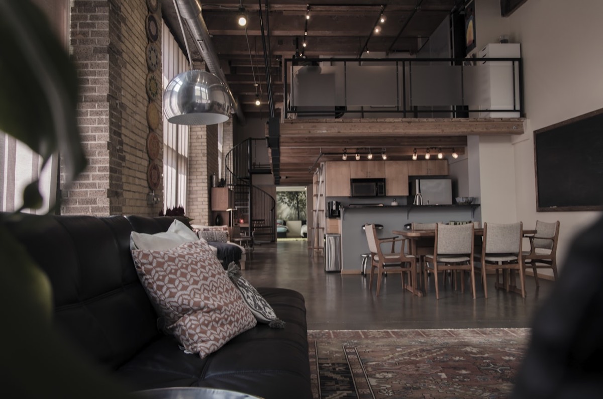 Loft industriel aux briques apparentes et poutres métalliques, esthétique du lieu brut pour un événement