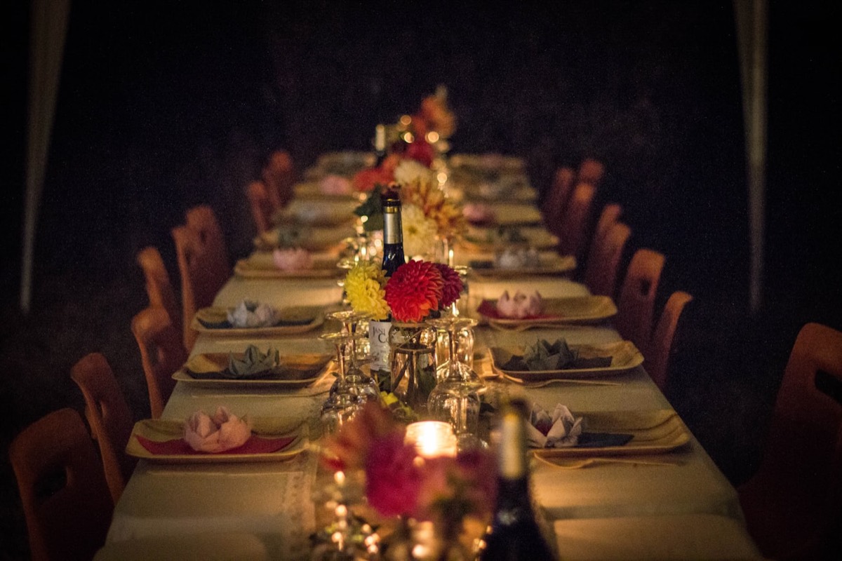Longue table dressée aux chandelles pour un dîner intimiste, micro-événement de marque à fort impact